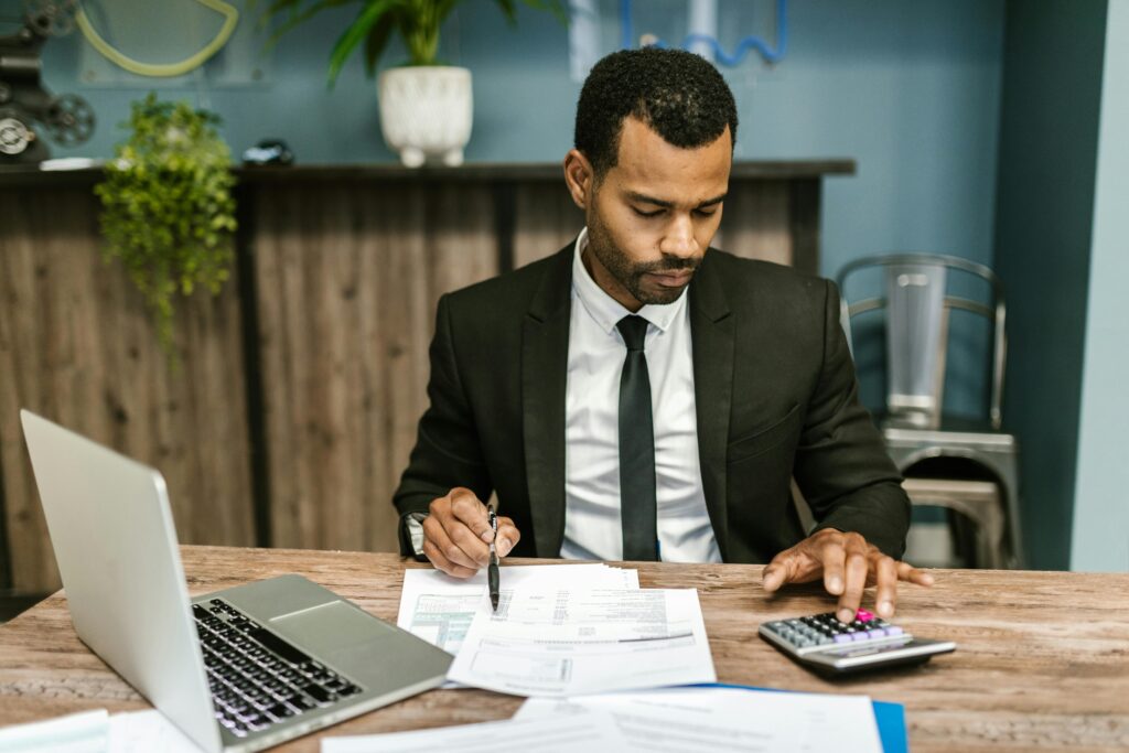 Man reviewing paperwork and using calculator