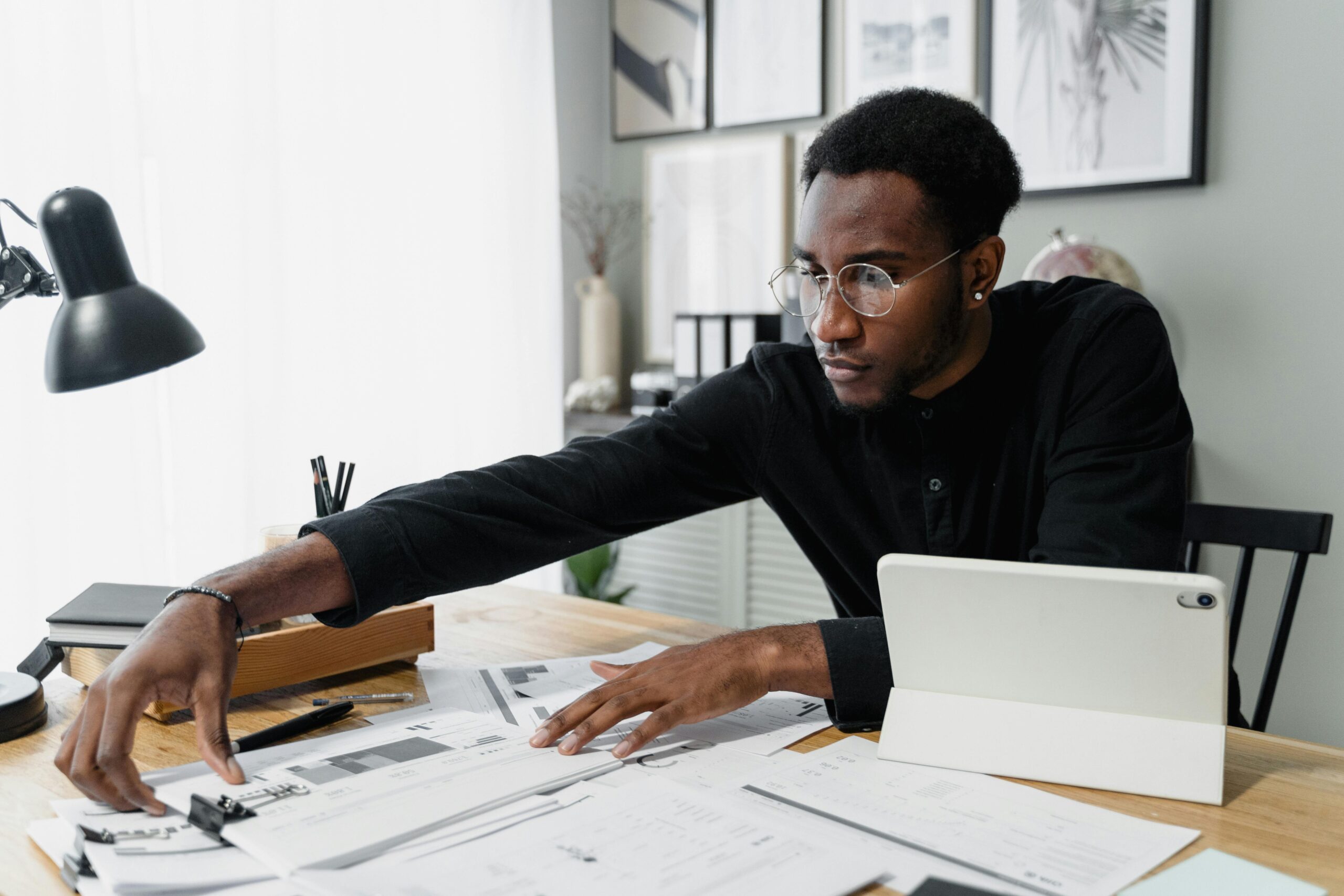 Man sorting through paperwork on desk